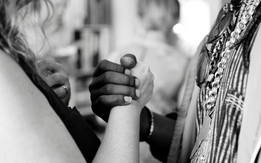 Black woman shaking hands with a white woman.