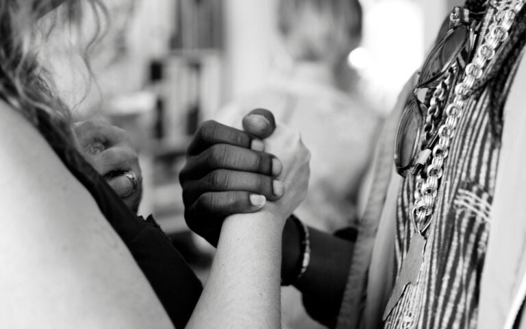 Black woman shaking hands with a white woman.