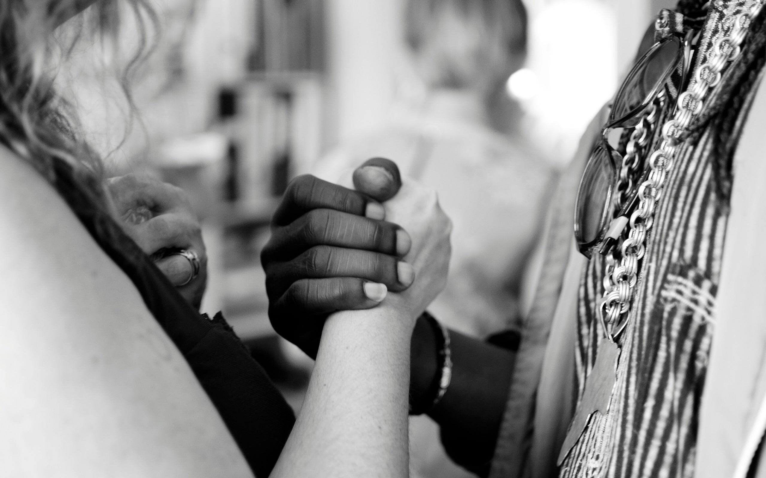 Black woman shaking hands with a white woman.