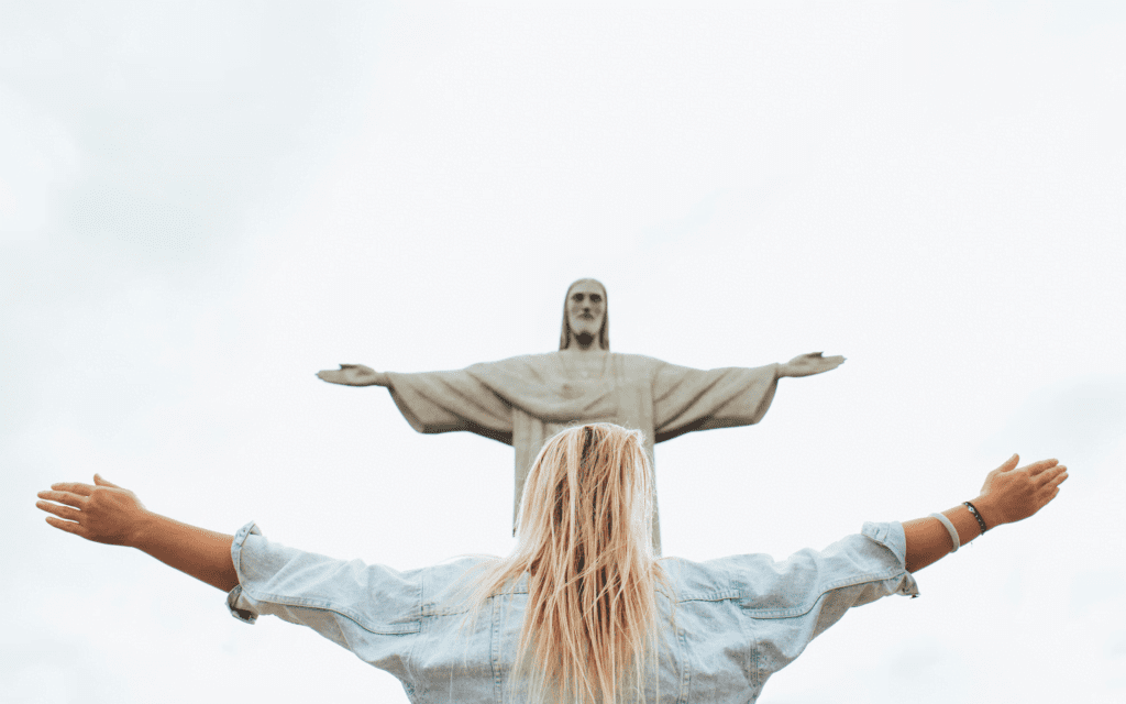 A woman standing in front of a Jesus icon.