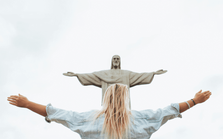 A woman standing in front of a Jesus icon.