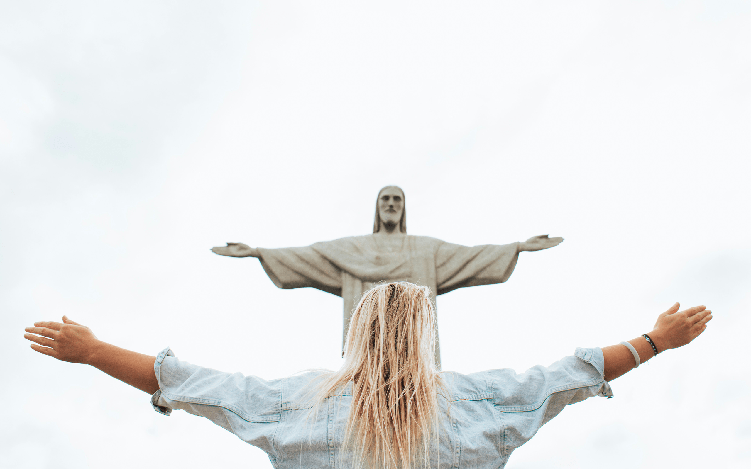 A woman standing in front of a Jesus icon.